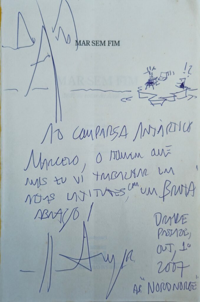 Página de rosto do livro Mar sem fim com dedicatória manuscrita de Amyr Klink a Marcelo Fleury, com desenhos de montanhas e de um barco, datada de 2007.