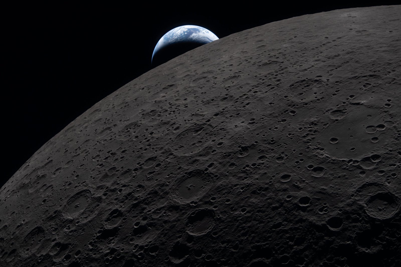 A Terra se ergue sobre a superfície lunar escura,